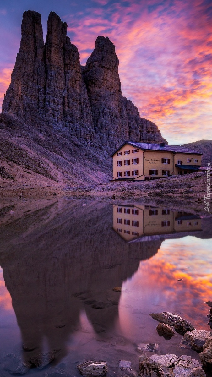 Kolorowe niebo nad szczytem Vajolet Towers i schroniskiem