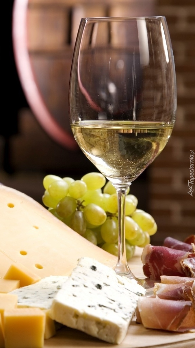 Lampka wina obok sera i winogron