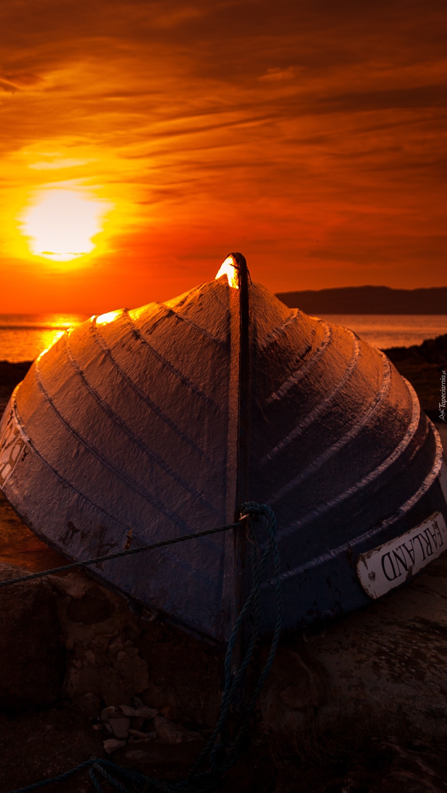 Łódka na brzegu o zachodzie słońca