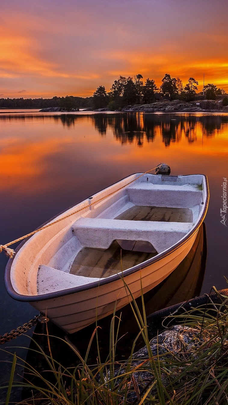Łódka nad jeziorem o zachodzie słońca