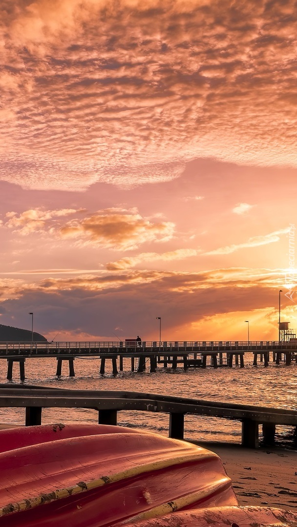 Łódki na plaży obok mola