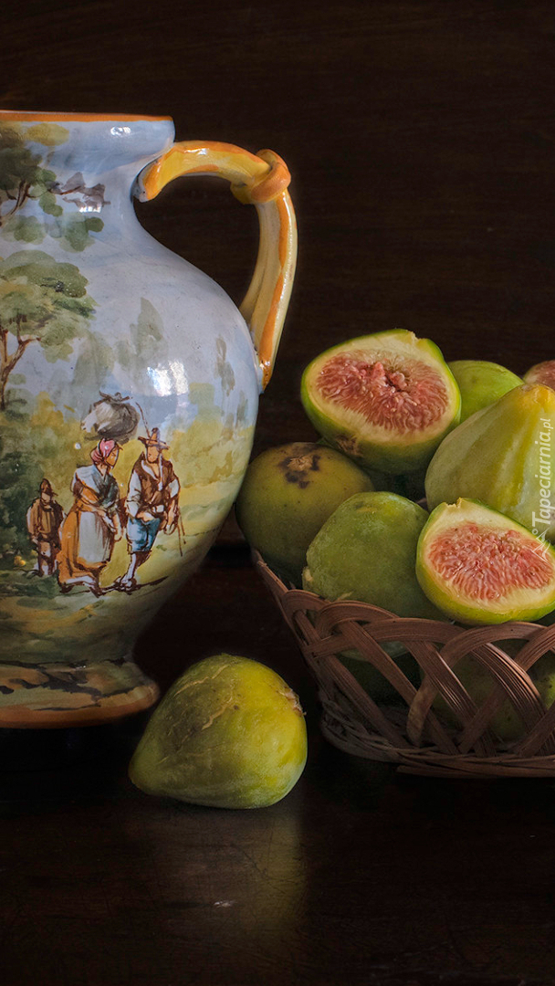 Malowany dzban obok fig w koszyczku