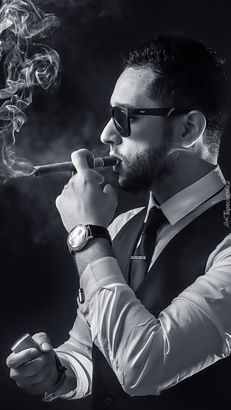 Mężczyzna w okularach palący cygaro