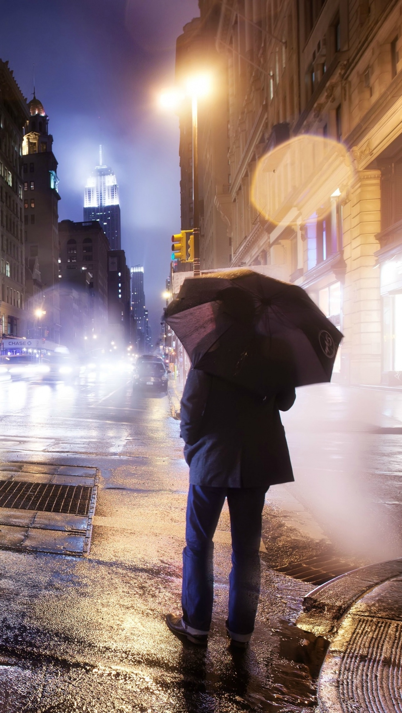 Mężczyzna z parasolem w deszczu na ulicy miasta
