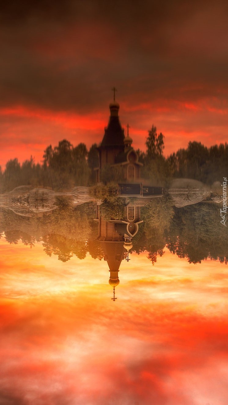Mglisty zachód słońca nad jeziorem i cerkwią