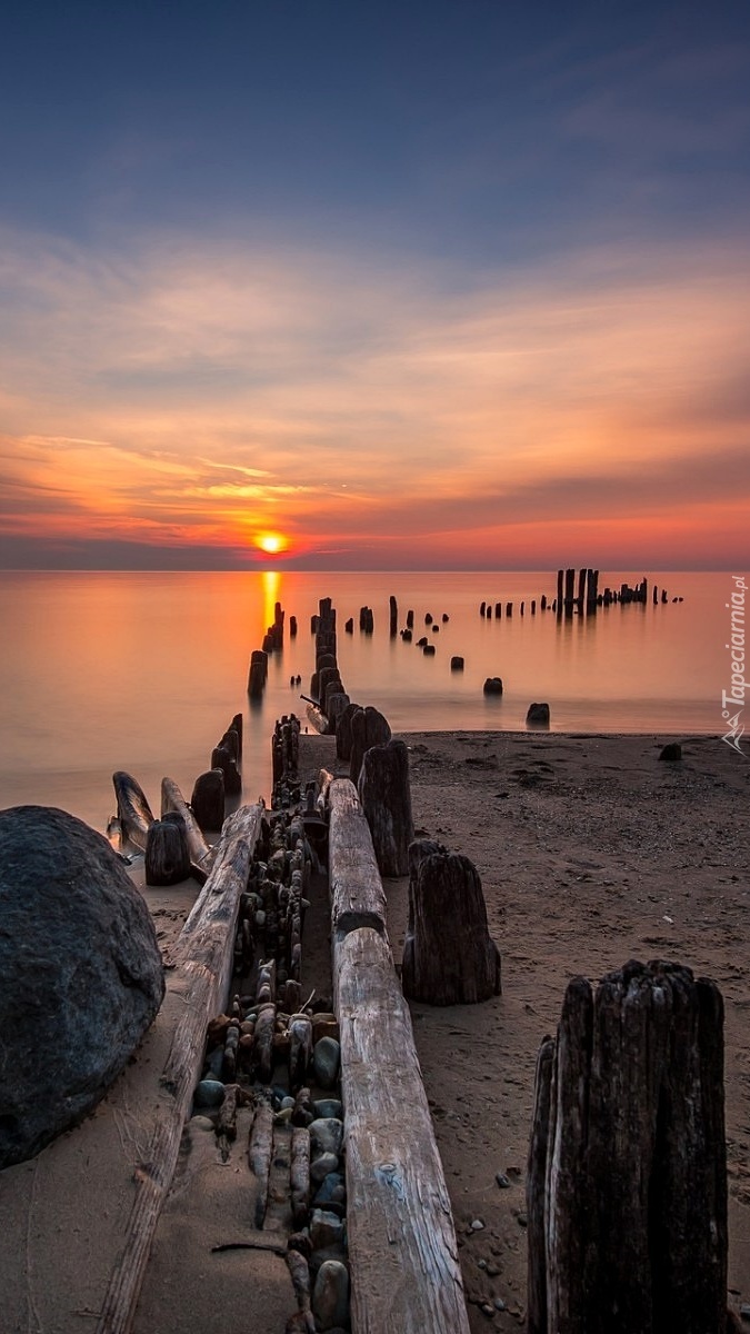 Morze i plaża o zachodzie słońca