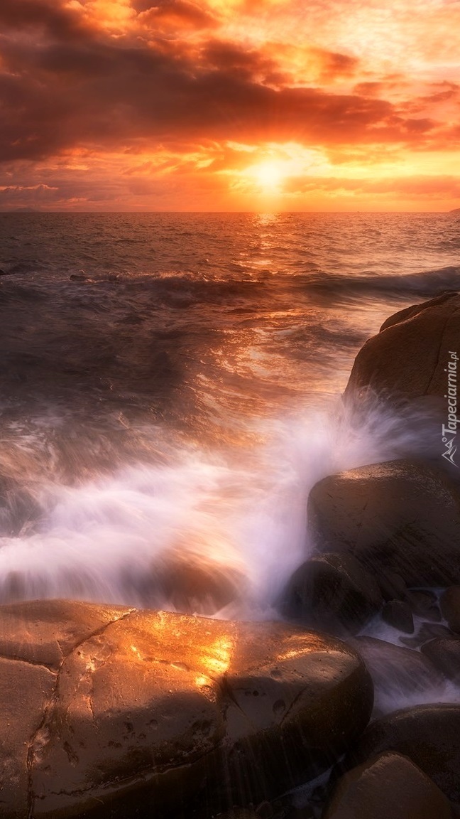 Morze oblewające kamienie o zachodzie słońca