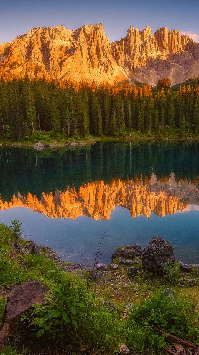 Odbicie rozświetlonych Dolomitów w jeziorze Carezza