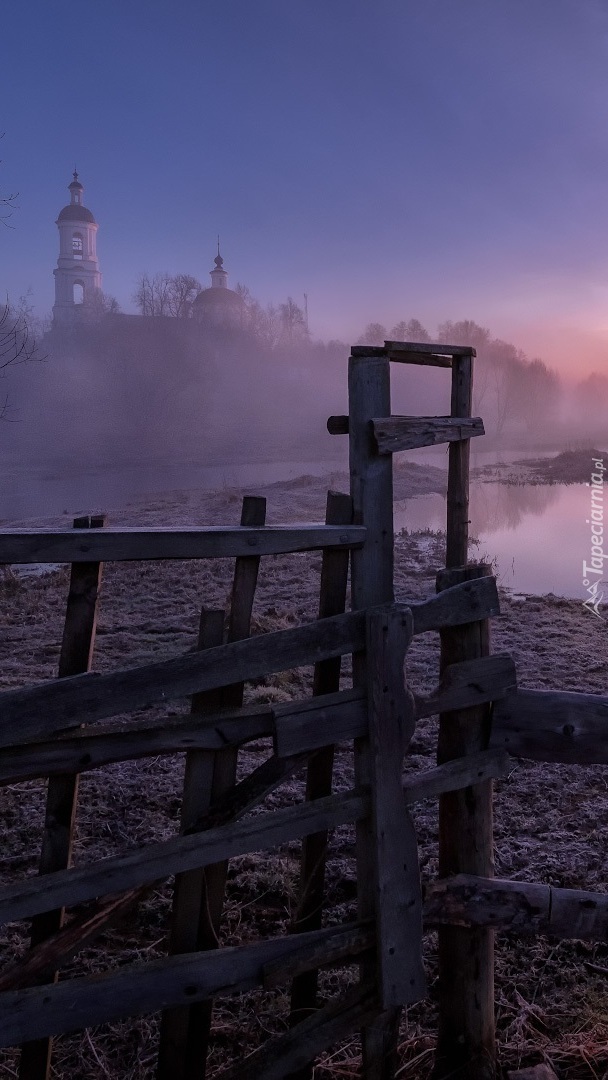 Ogrodzenie nad rzeką i cerkiew w tle