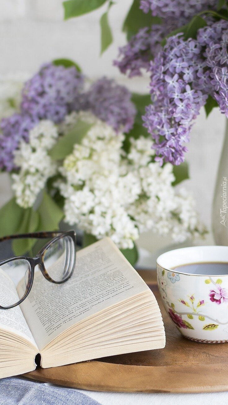 Okulary na książce obok filiżanki kawy