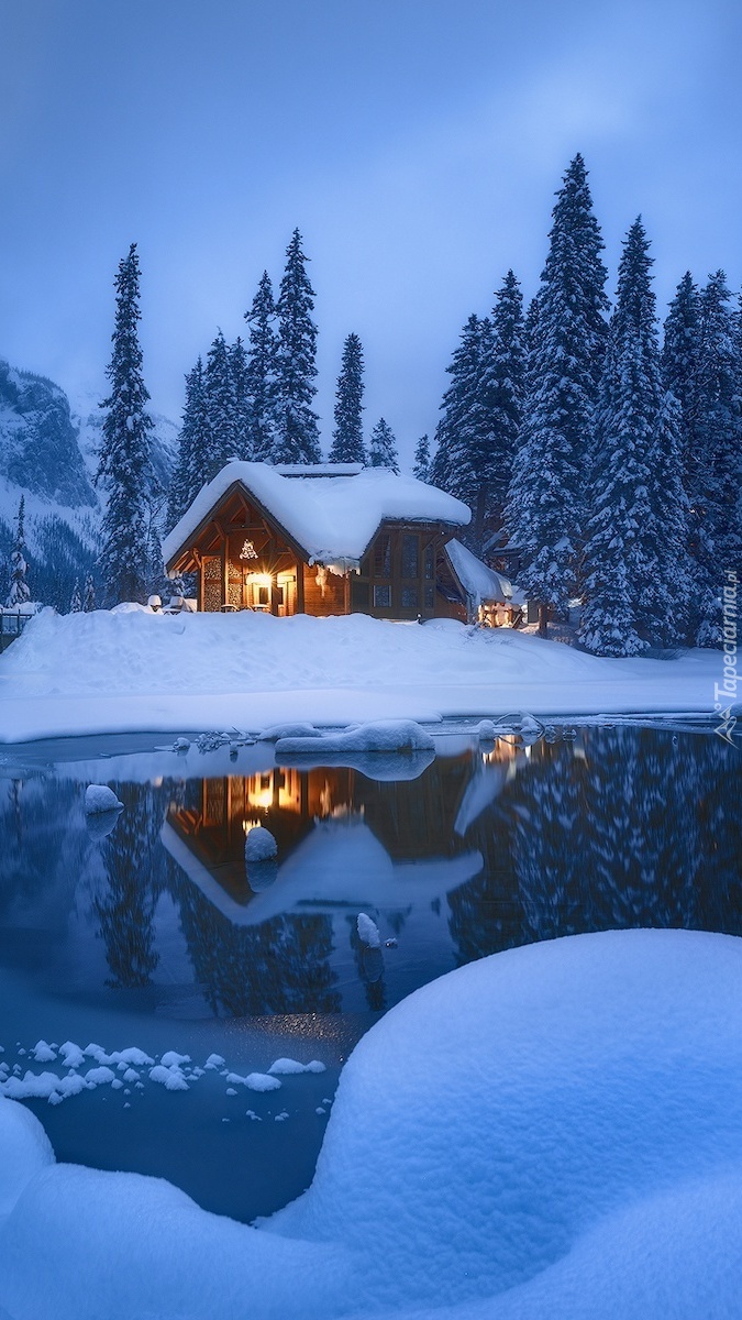 Ośnieżony dom i drzewa nad jeziorem Emerald Lake