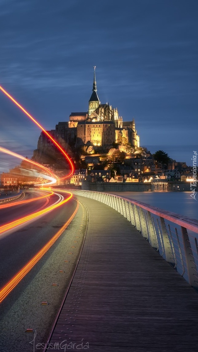 Oświetlona droga i klasztor Mont Saint Michel