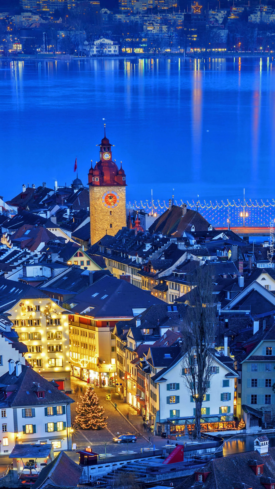 Oświetlone domy i wieża zegarowa w Lucernie