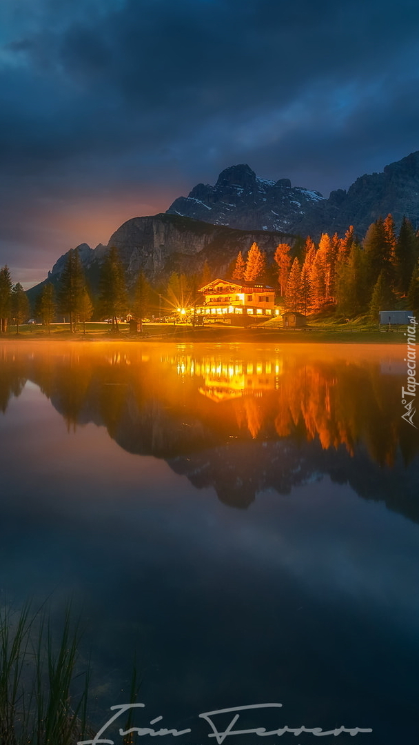 Oświetlony dom nad jeziorem Antorno Lake