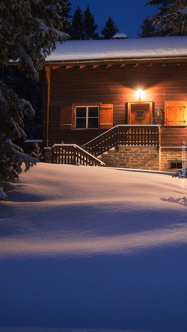 Oświetlony dom w śniegu