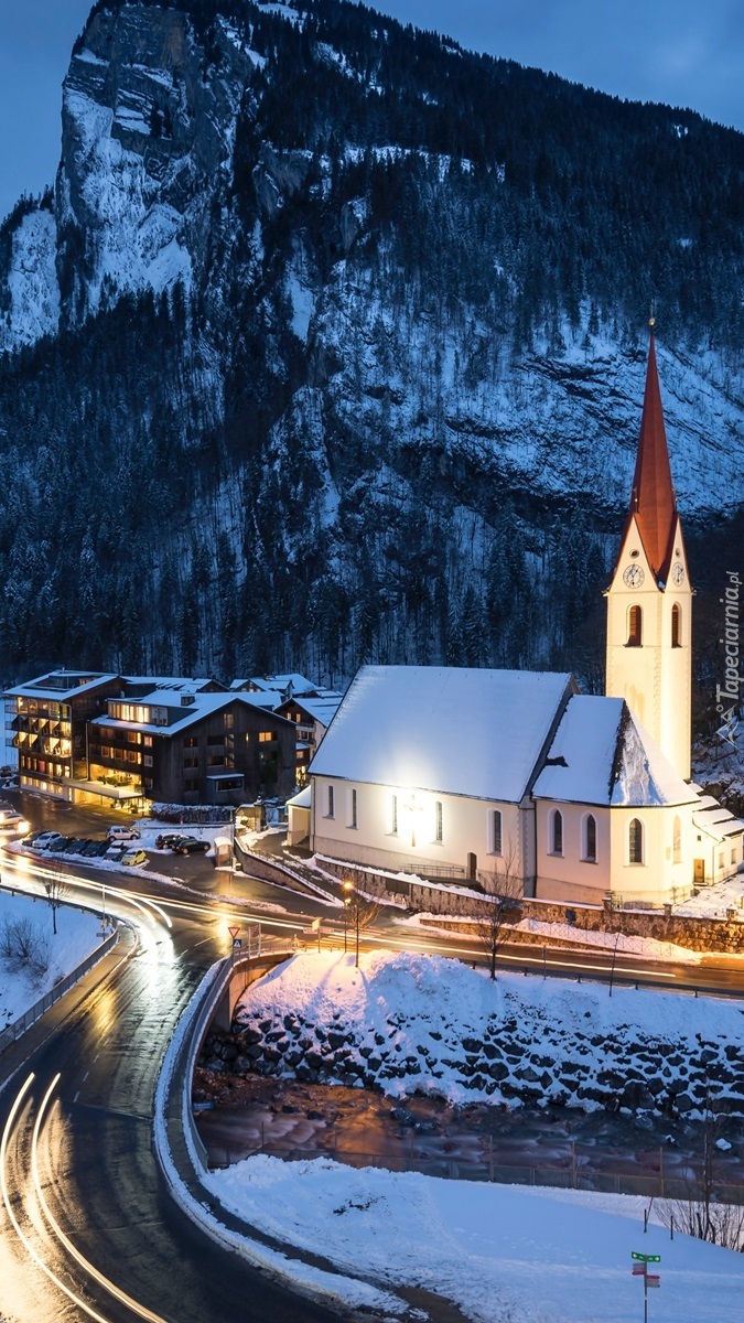 Oświetlony kościół w górskim miasteczku
