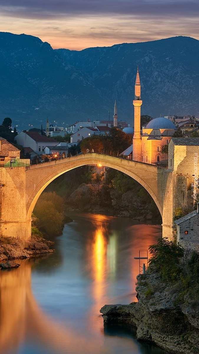 Oświetlony nocą most nad rzeką Neretwa w Mostar