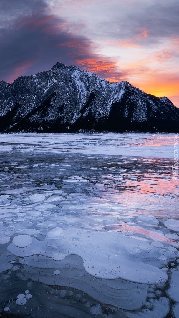 Pokryte lodem jezioro Abraham Lake i góry Canadian Rockies