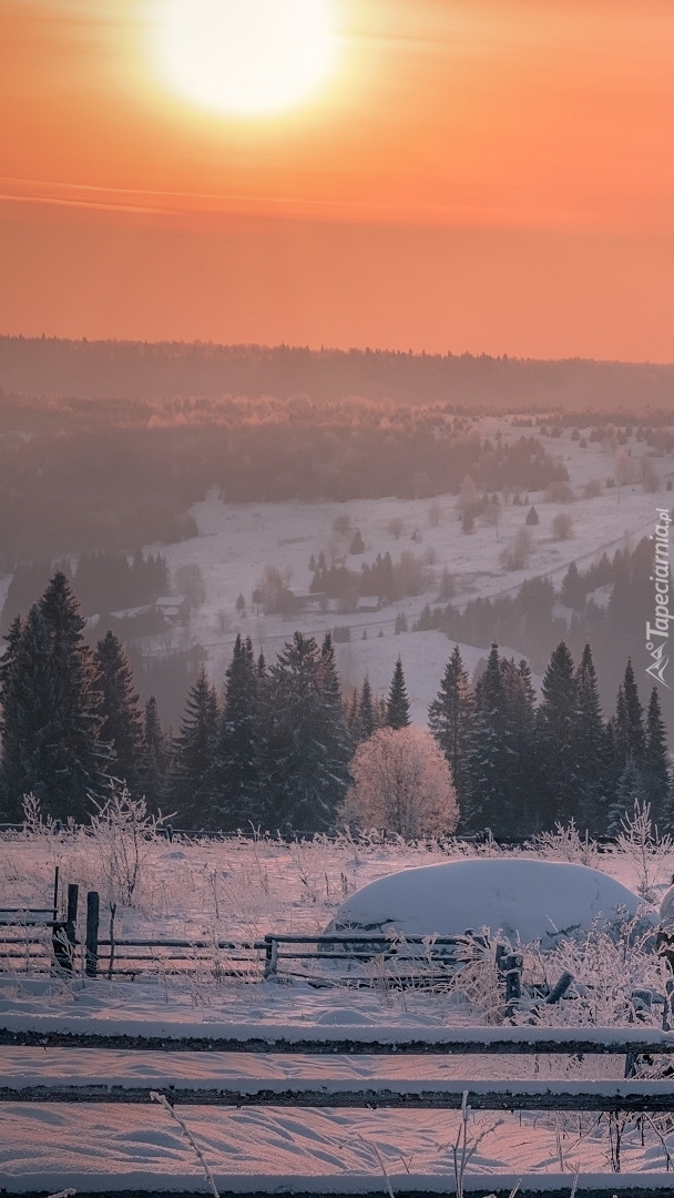 Pomarańczowe niebo nad zamglonymi wzgórzami