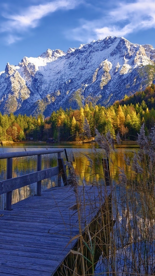 Pomost na jeziorze na tle ośnieżonych gór