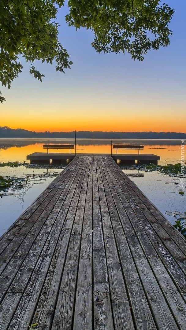 Pomost nad jeziorem o zachodzie słońca