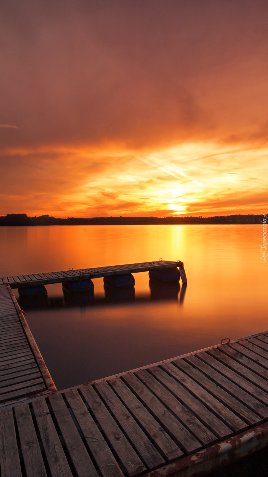 Pomost nad jeziorem w blasku zachodzącego słońca