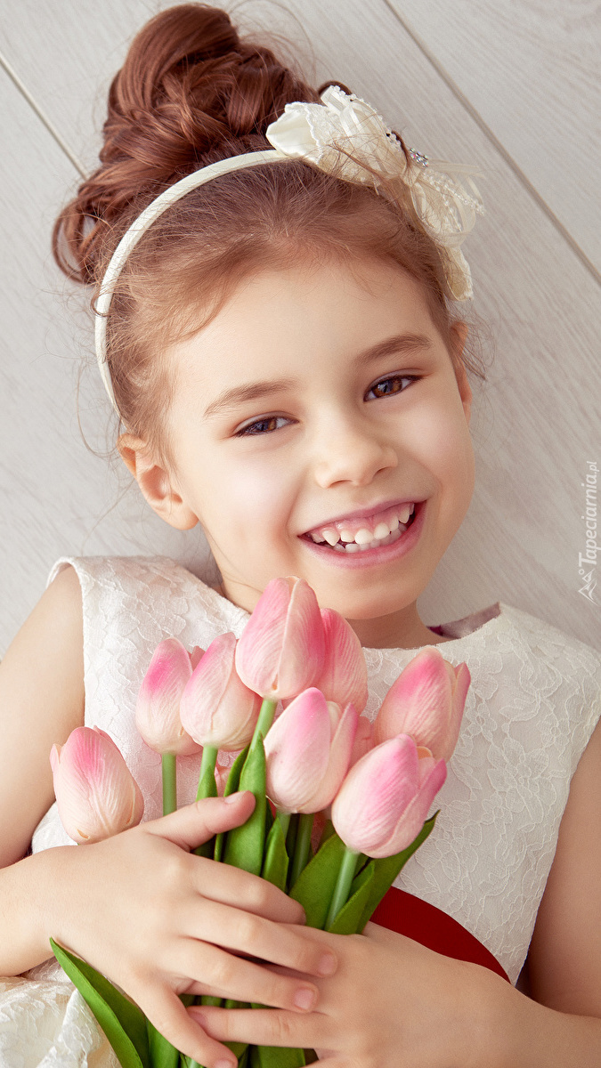 Radosna dziewczynka z bukietem tulipanów