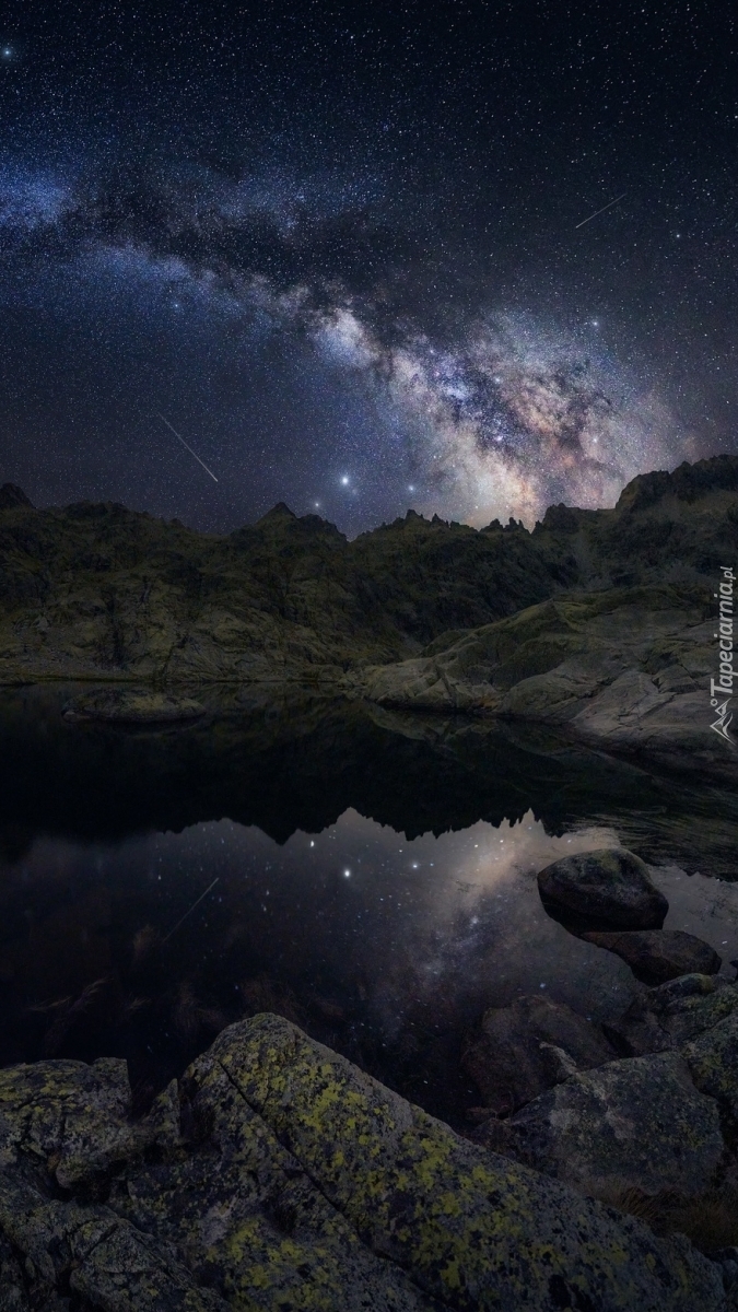 Rozgwieżdżone niebo nad jeziorem nocą