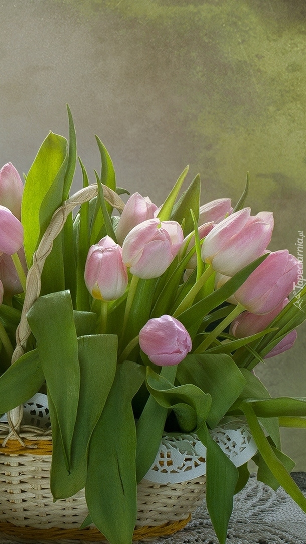 Różowe tulipany w plecionym koszyku z białą serwetką