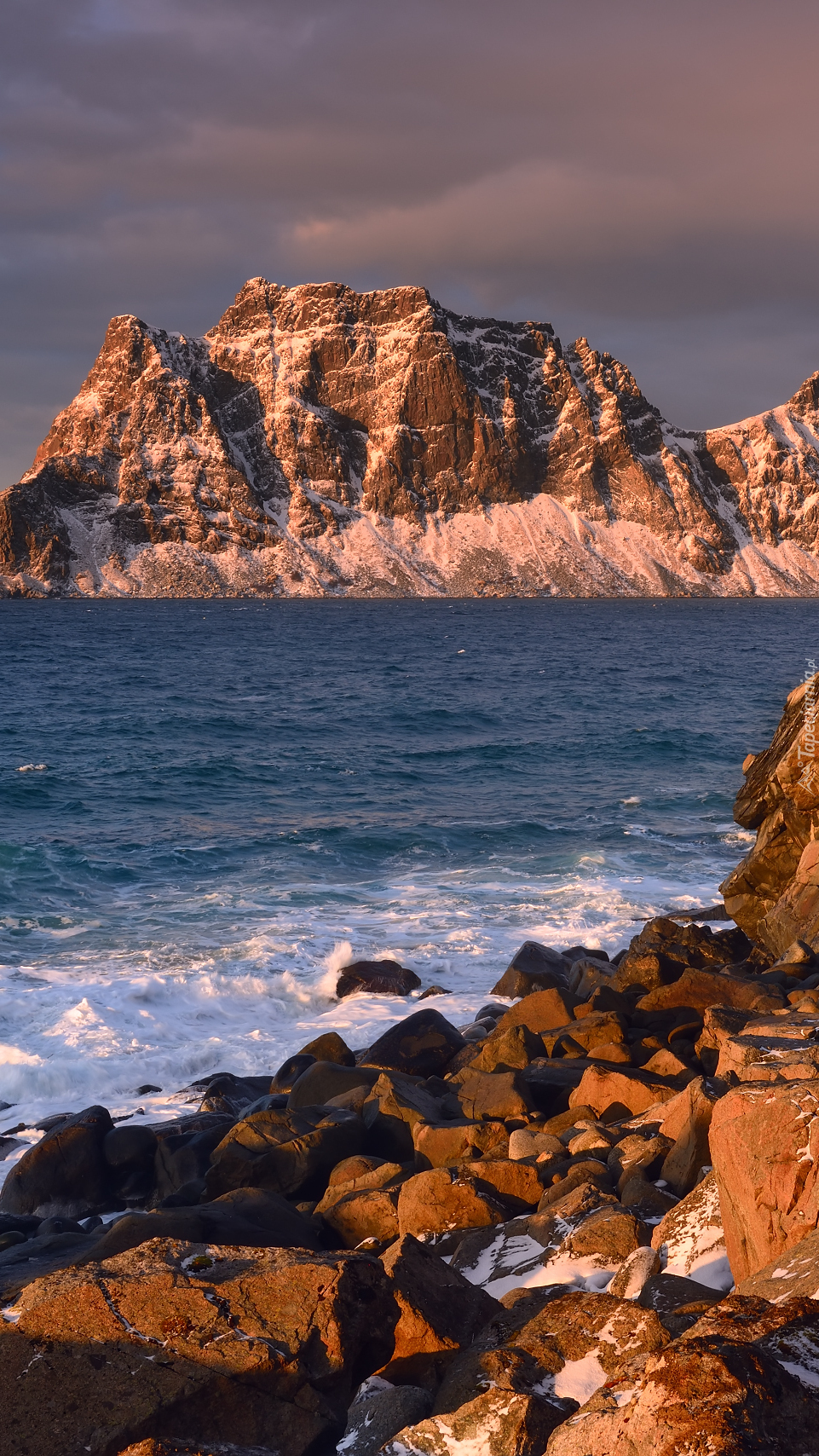 Rozświetlone góry i skały nad morzem