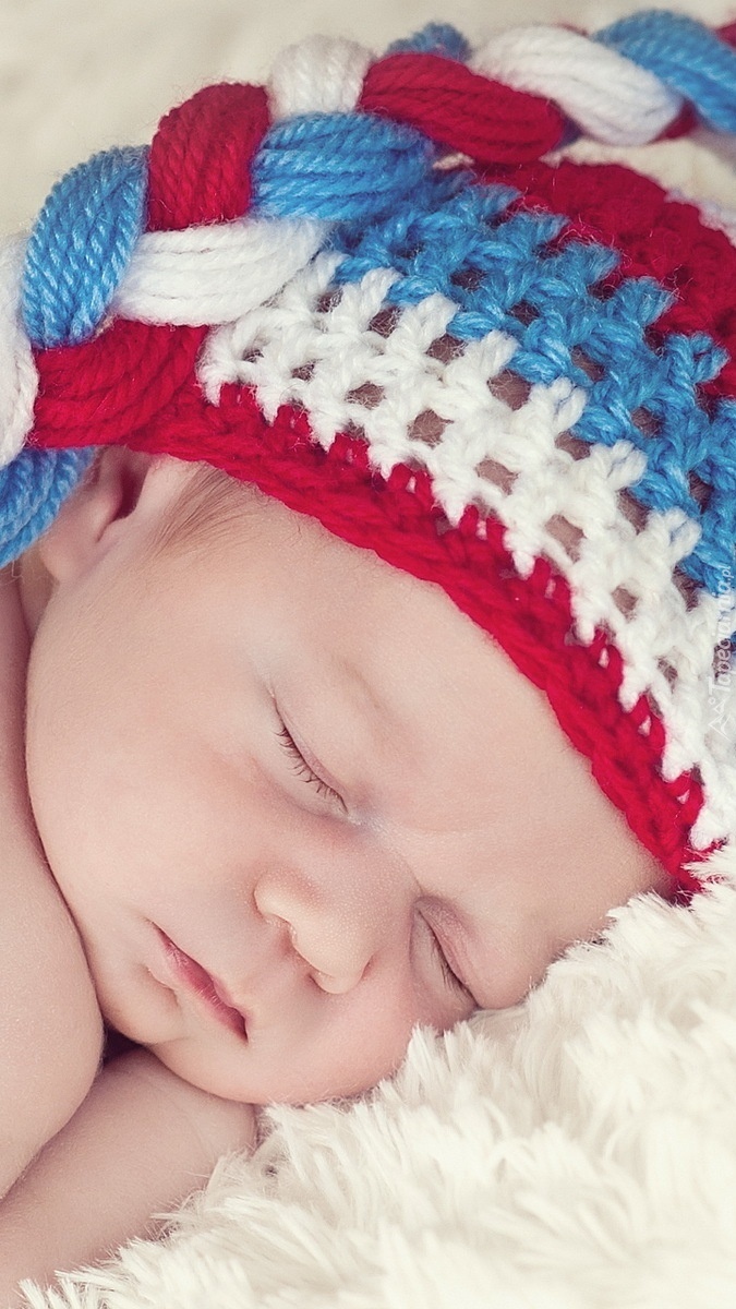 Śpiące niemowlę w kolorowej czapeczce