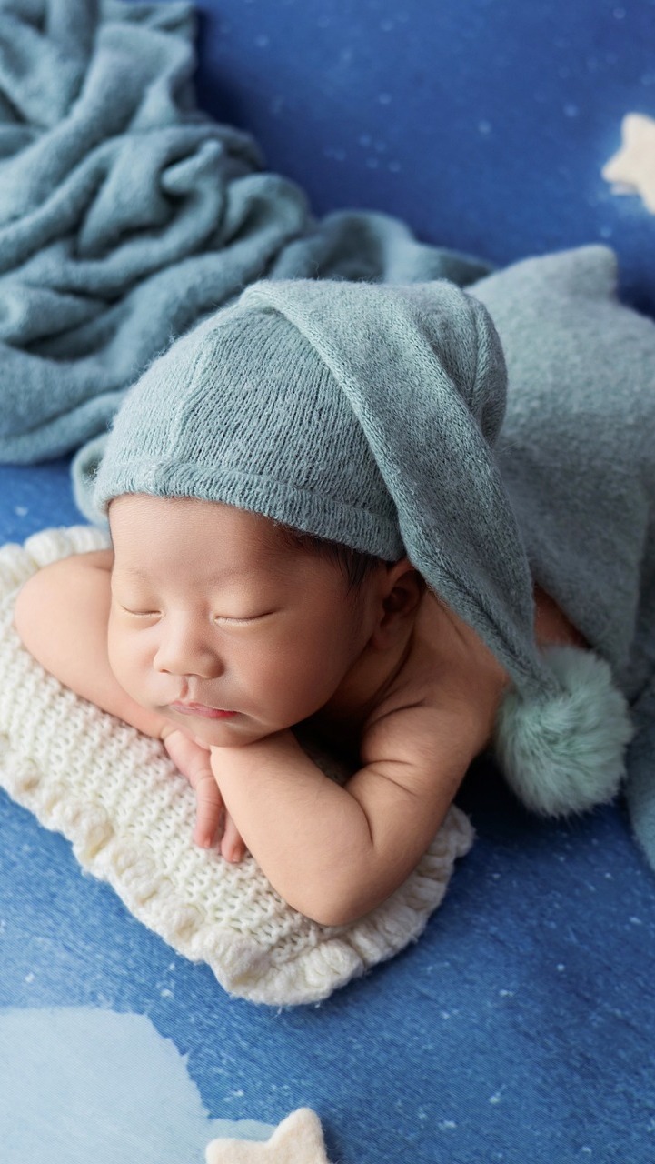 Śpiące niemowlę w niebieskiej czapeczce