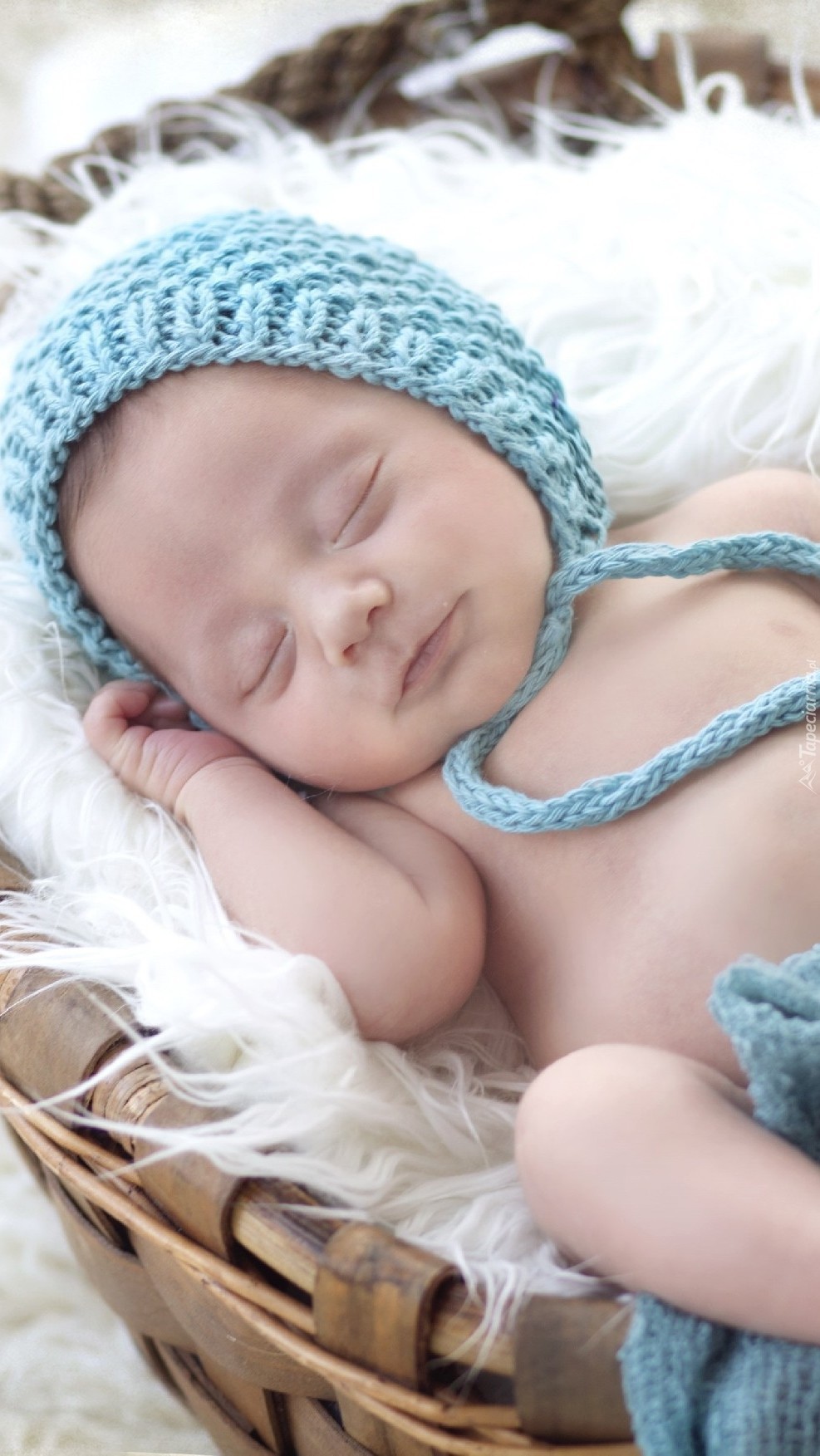 Śpiące niemowlę w niebieskiej czapeczce