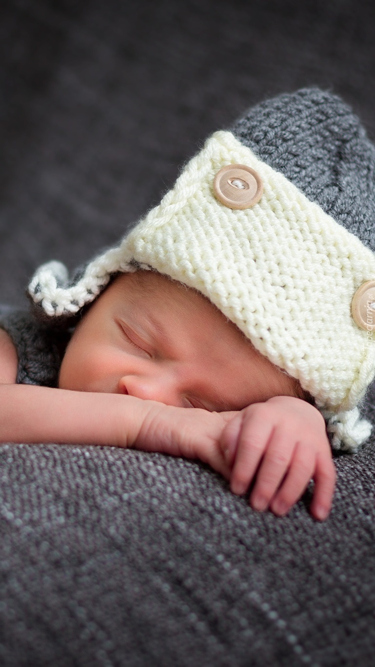 Śpiące niemowlę w wełnianej czapeczce