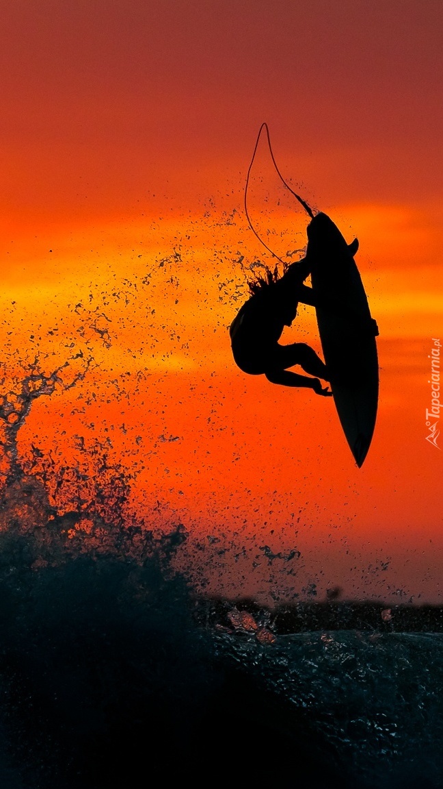 Surfer w zachodzącym słońcu