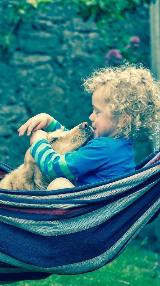 Szczęśliwe dziecko z psem na hamaku