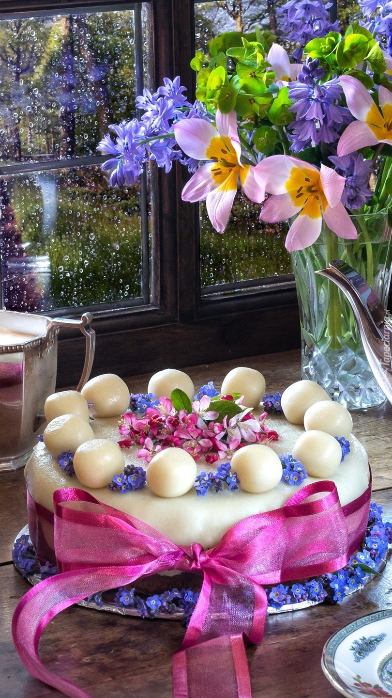 Tort obok kwiatów w wazonie