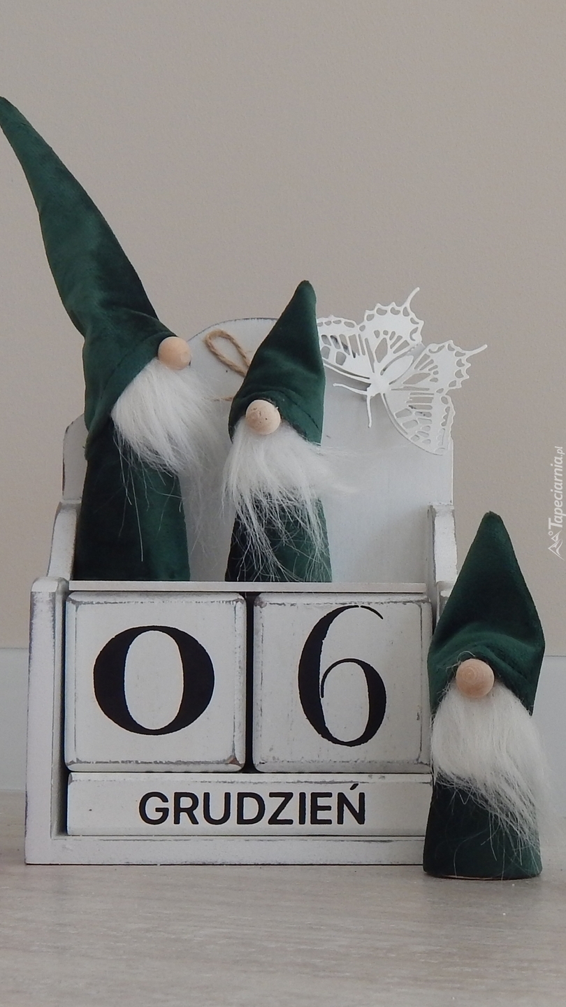 Trzy Mikołaje przy pudełku z datą
