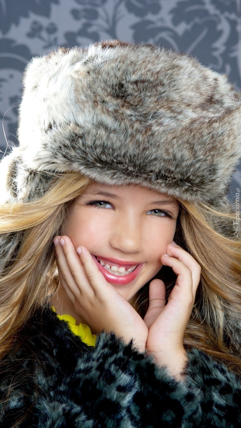 Uśmiechnięta dziewczynka w futrzanej czapce