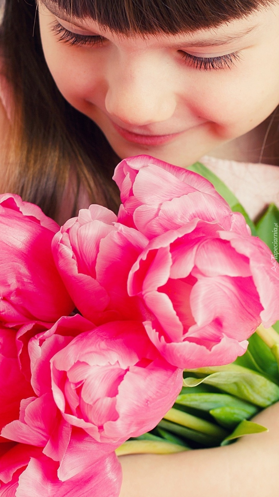 Uśmiechnięta dziewczynka z bukietem tulipanów