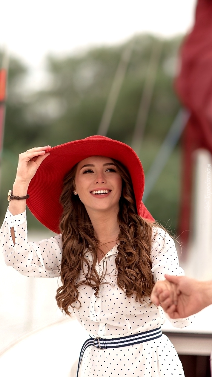 Uśmiechnięta kobieta w czerwonym kapeluszu