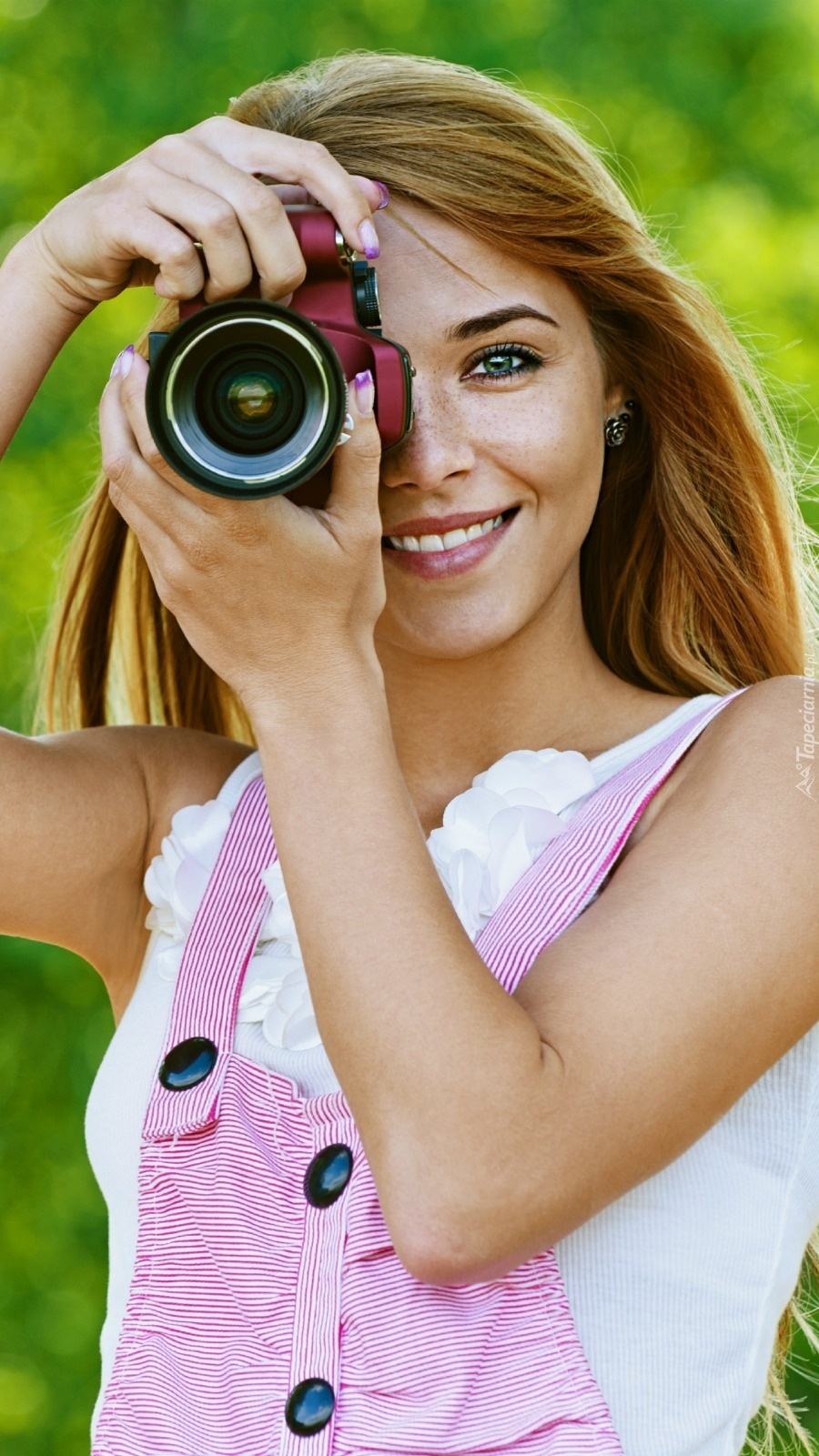 Uśmiechnięta  kobieta z aparatem fotograficznym