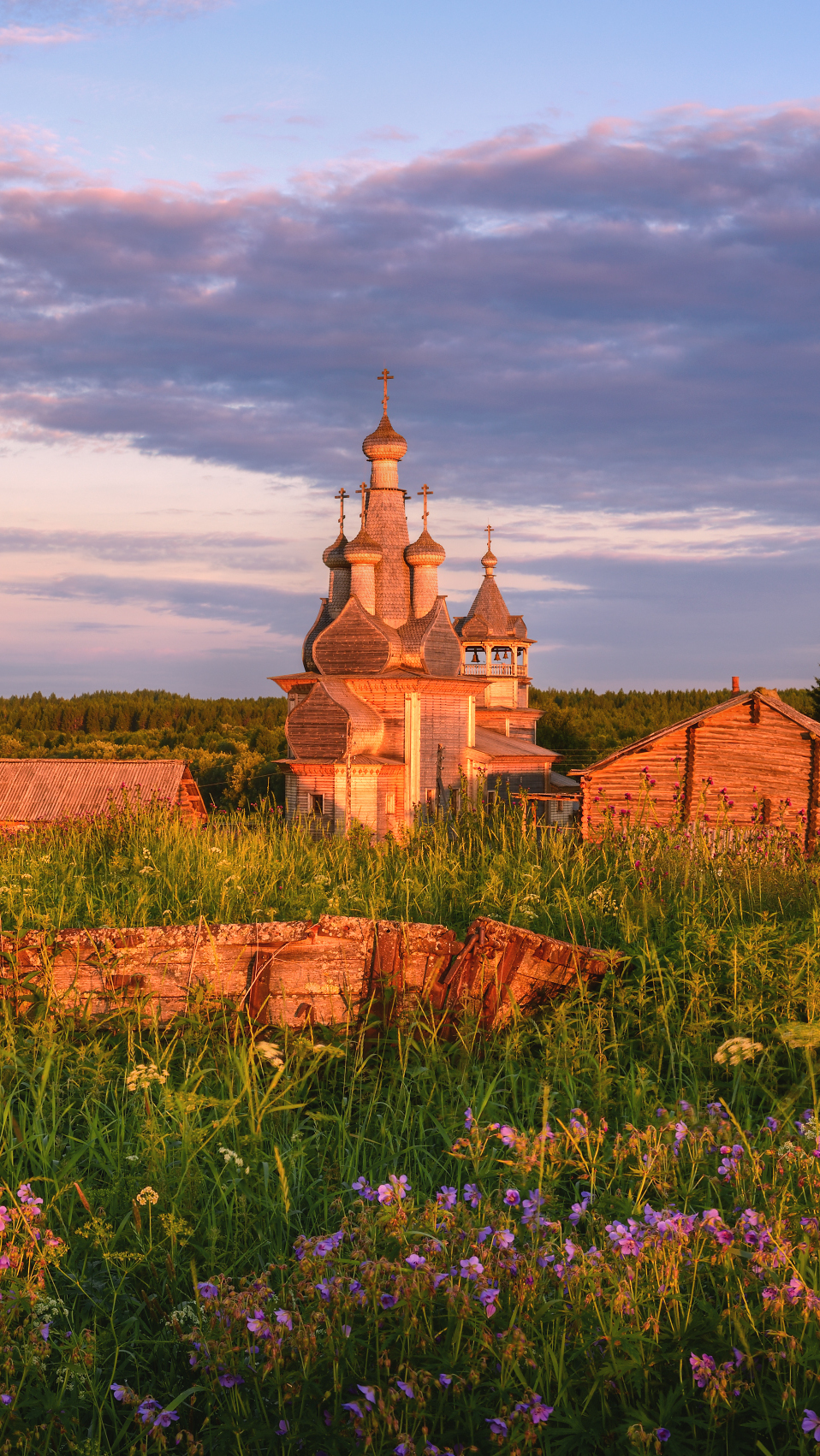 Widok z łąki na rozświetloną cerkiew we wsi Kimzha