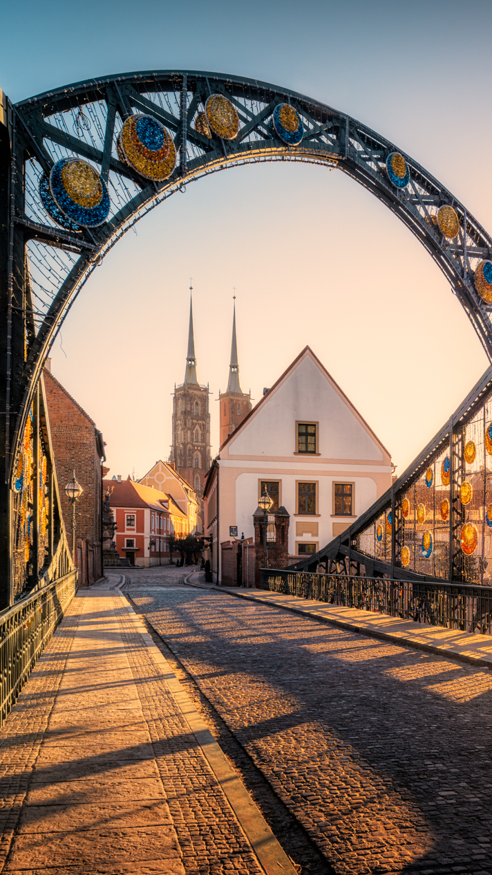 Widok z Mostu Tumskiego we Wrocławiu na domy i kościół