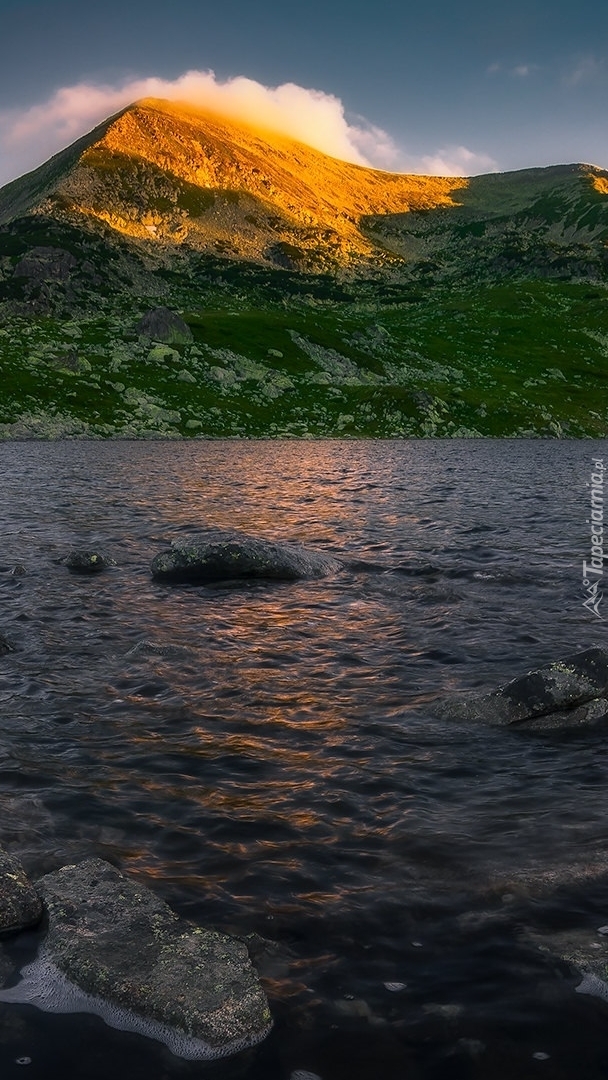 Widok znad jeziora na rozświetlony szczyt