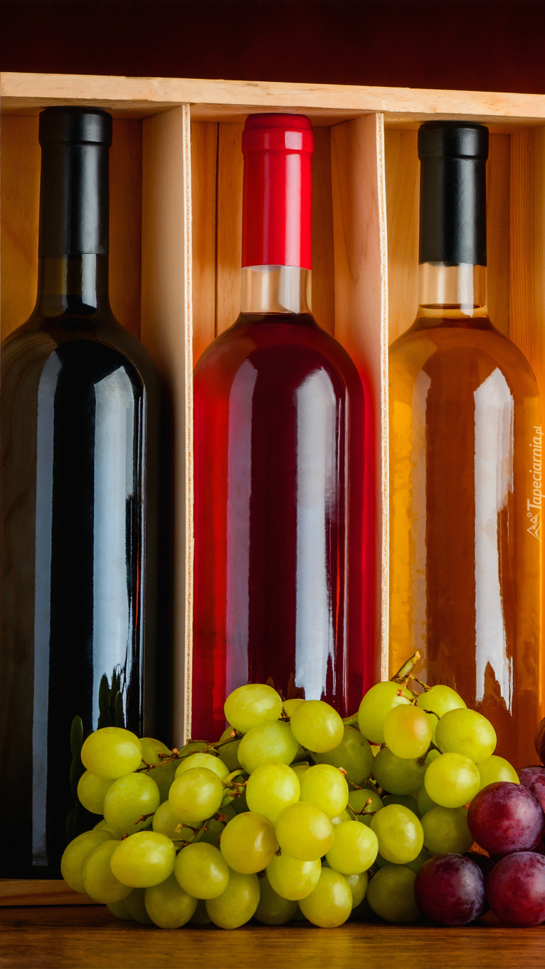 Winogrona przy butelkach z winem