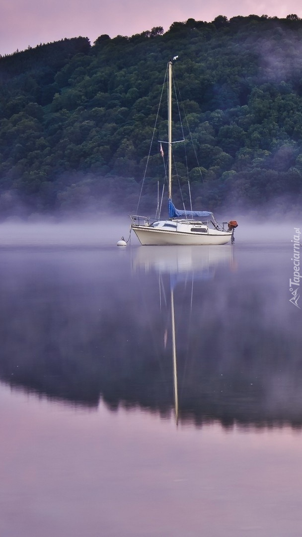 Żaglówka na jeziorze we mgle