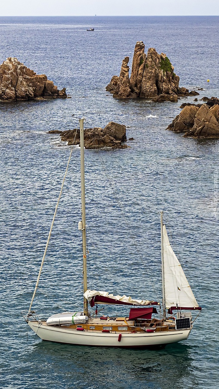 Żaglówka obok skał na morzu