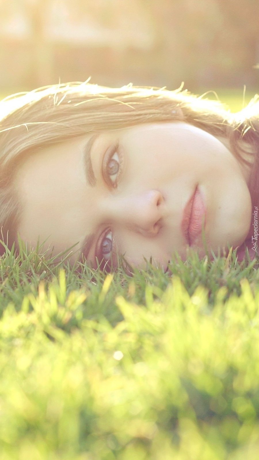 Zamyślona kobieta leży na trawie