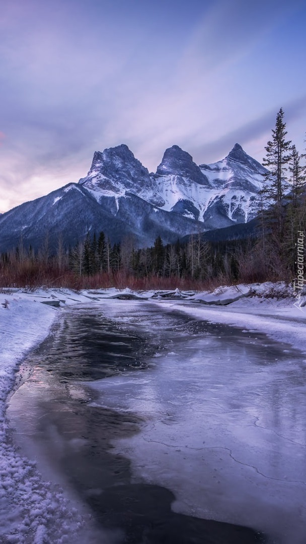 Zaśnieżona rzeka i góra Three Sisters w Kanadzie